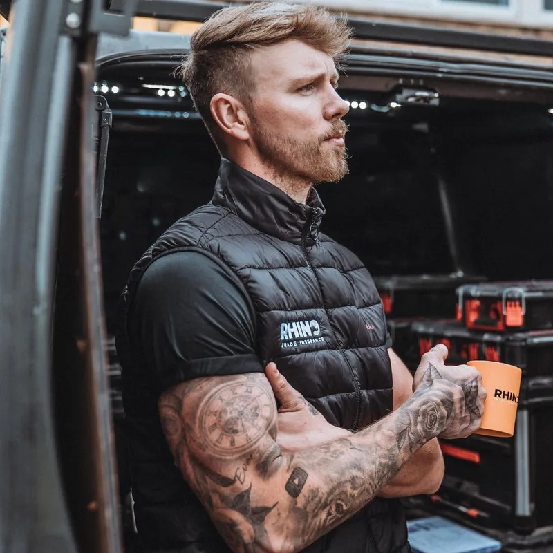 Nick Bundy standing by his van, holding a mug